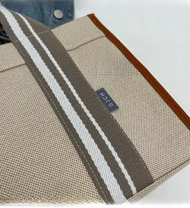 Gros plan du sac cabas en toile montrant la texture du tissu et les détails de couture en cuir