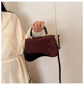 Detail showing red snakeskin flap and black leather base with wavy bottom design