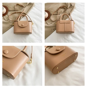 Detail view of light brown leather box bag showing base rivets and hardware