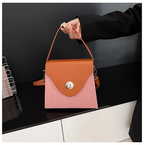 Detail of color-block handbag with orange flap and pink wavy textured leather pattern
