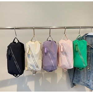 Row of colorful nylon crossbody bags hanging on a rack showing various color options
