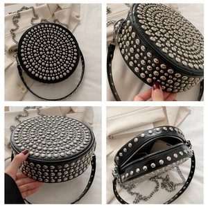 Detail view of round punk crossbody bag with silver rivets and metal chain strap
