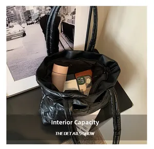 Internal capacity of black quilted puffer tote bag showing large storage for daily items