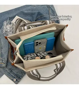 Vue détaillée de l'intérieur du sac fourre-tout rayé avec compartiments et poche zippée
