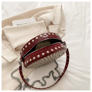 Detail view of round burgundy rivet bag showing capacity to hold a smartphone easily