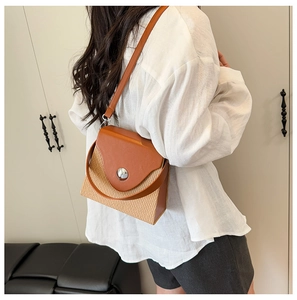 Detail of a retro woven crossbody bag featuring contrast stitching and a round metal buckle