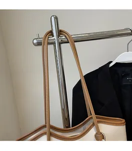 Detail of soft cream leather tote bag with brown straps and silver metal rings