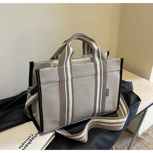Detail of canvas tote bag with brown stripes and detachable wide crossbody strap