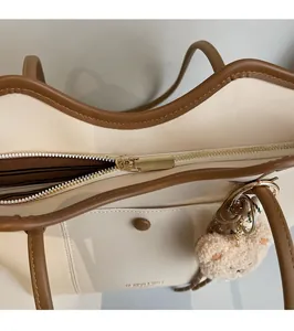 Detail of golden metal zipper and smooth stitching on the ivory tote bag