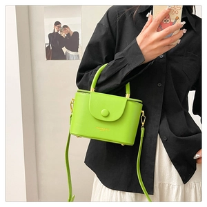 Detailed shot of a bright neon green structured mini box bag with gold metal hardware