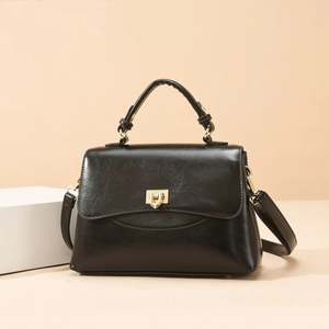 Classic black oily leather top handle bag with gold hardware and adjustable strap