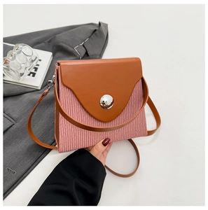 Detail of pink pleated fabric and brown leather flap with round metal buckle