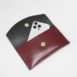 Detailansicht der zweifarbigen Clutch aus Leder in Rot und Schwarz mit Magnetverschluss