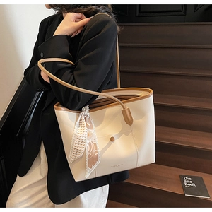 Detail of beige tote bag with brown trim, vintage button and decorative silk scarf