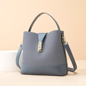 Chic Morandi blue bucket bag with woven texture and gold metal buckle on beige background