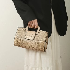 Close-up of beige crocodile pattern embossing on minimalist tote bag with handle detail
