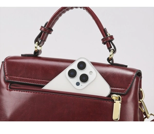 Macro shot of dark red leather handbag back zipper pocket fitting a smartphone