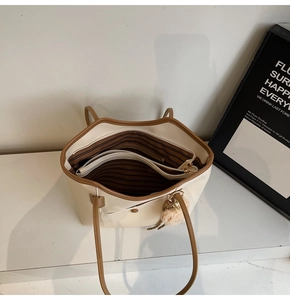 Detail view of large capacity tote bag featuring brown zip compartments and striped lining