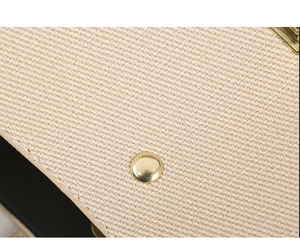 Close-up of beige twill fabric texture and premium golden metal hardware with stitching
