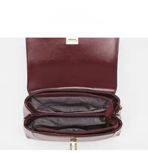 Interior detail of burgundy handbag showing multi-compartment lining and zipper pockets