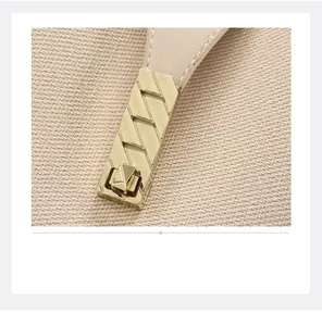 Detail of leather stitching and gold metal twist lock on woven fabric tote bag