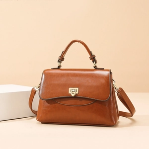 Braune Vintage-Tasche aus Kunstleder mit Goldschnalle und Griff in minimalistischer Szene