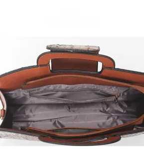 Detail view of the brown crocodile-pattern tote bag interior with a zippered pocket