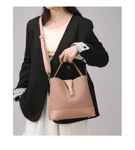 Detail of pink crossbody bucket bag with golden metal buckle and adjustable strap