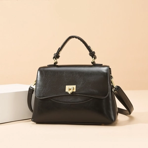 Minimalistische Handtasche aus schwarzem Leder mit goldener geometrischer Schnalle