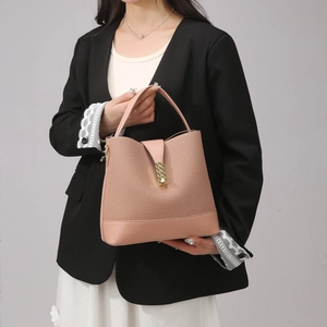 Detail of the minimalist pink handbag featuring mixed leather fabric and gold buckle accent