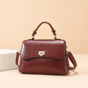 Minimalistische weinrote Lederhandtasche mit goldenem Schloss und Schultergurt