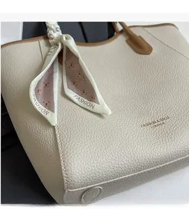 Detailed macro view of cream tote bag with litchi texture and silk scarf accessory