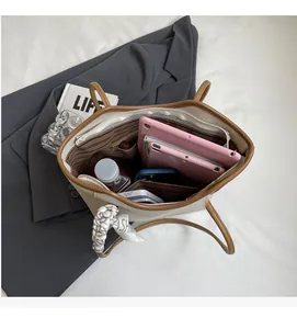 Top view of spacious beige tote bag interior with multiple pockets holding a tablet and items
