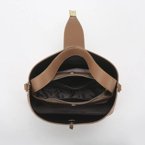 Top view of brown leather handbag interior showing multiple compartments and gold zipper