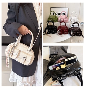 Détail du sac à main Boston en cuir PU brillant avec poches et pompon décoratif