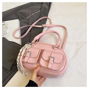 Sac à main rose en cuir PU avec breloque cœur en métal et nœud tressé sur fond blanc