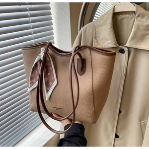 Detail of light brown lychee leather tote with brown trim and decorative fashion scarf