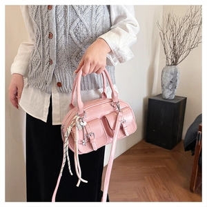 Sac Boston en cuir verni rose avec poches à boucles et pendentif clé en détail