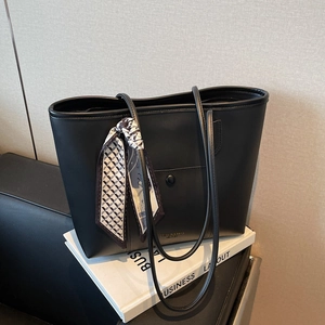 Minimalist black leather tote bag with silk scarf and front pocket for commute