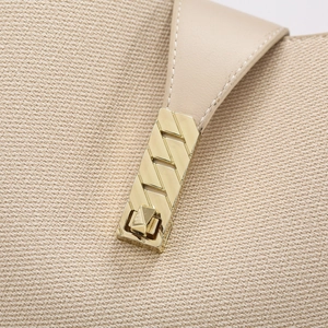 Macro shot of stylish gold metal buckle and woven fabric detail on the bucket bag