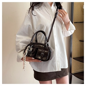Vue détaillée du sac vintage en cuir brillant marron avec poches à boucles