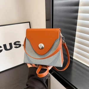 Fashionable contrast color shoulder bag with grey corduroy and orange leather panels