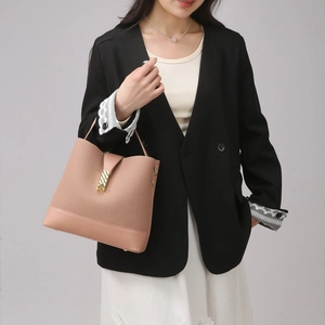Detail view of woven pink bucket bag featuring a decorative golden buckle lock