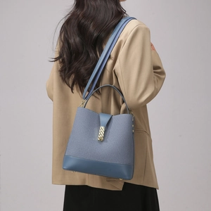 Detailed view of Morandi blue bucket bag on shoulder with gold clasp and fabric texture