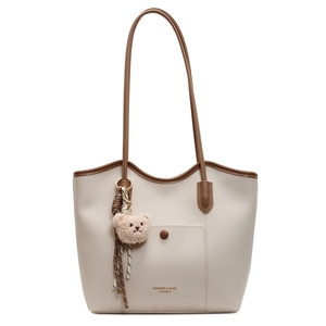 Cream tote bag with brown straps, front pocket, and cute bear charm for daily commute