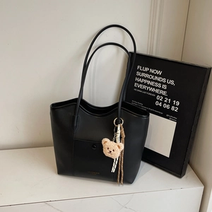 Large black matte tote bag with teddy bear pendant and woven tassel detail for women