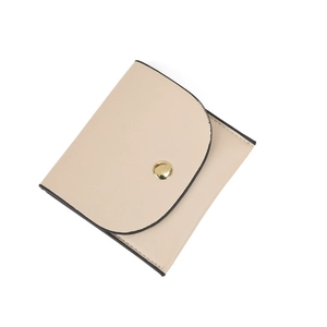 Detail of beige faux leather mini wallet with gold snap closure and black edge oil