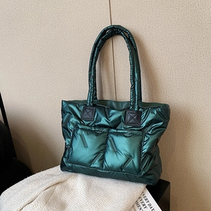 Quilted dark green puffer tote bag with glossy finish and dual front pockets for winter commuting