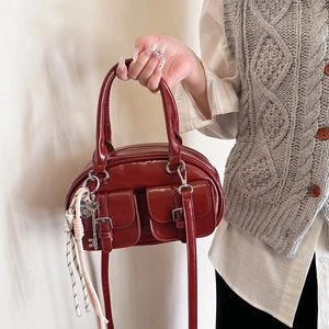 Sac bandoulière vintage rouge foncé avec deux poches avant et fini en cuir synthétique