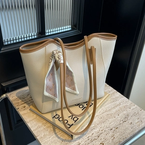 Off-white textured leather tote bag with brown trim and decorative silk scarf on handle